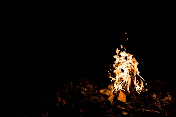 Chama e troncos no acampamento fogo na escuridão na noite — Fotografia de Stock