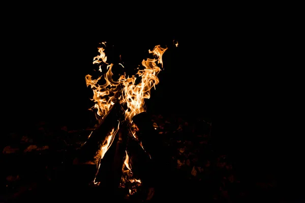 Grumes brûlant dans le feu de camp dans la nuit — Photo de stock