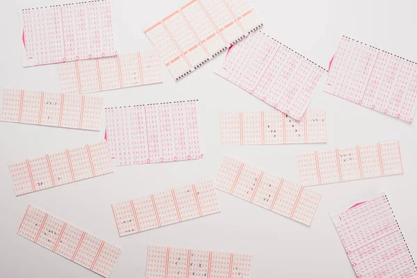 Vista superior de billetes de lotería dispersos en la mesa blanca - foto de stock