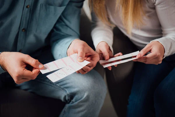 Partial view of two gamblers checking lottery tickets — Stock Photo
