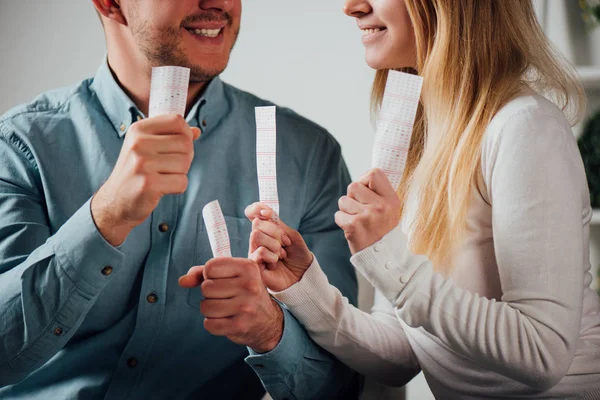 Обрізаний вид щасливого чоловіка і жінки, що тримає лотерейні квитки — стокове фото