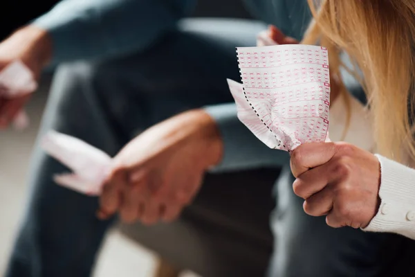 Vue recadrée de malheureux homme et femme tenant des billets de loterie froissés — Photo de stock