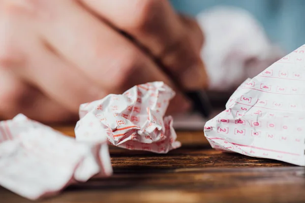 Selective focus of crumpled lottery tickets near hand of gambler — Stock Photo