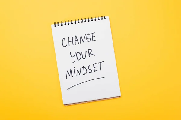 Vista superior do notebook com mudança sua inscrição mentalidade na superfície amarela — Fotografia de Stock