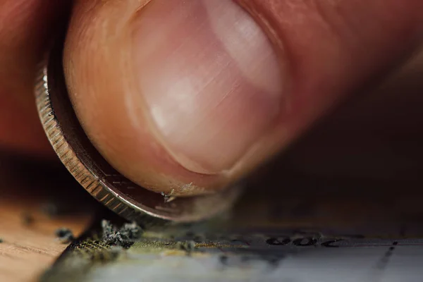 Close up view of silver coin and finger of gambler scratching lottery ticket — Stock Photo