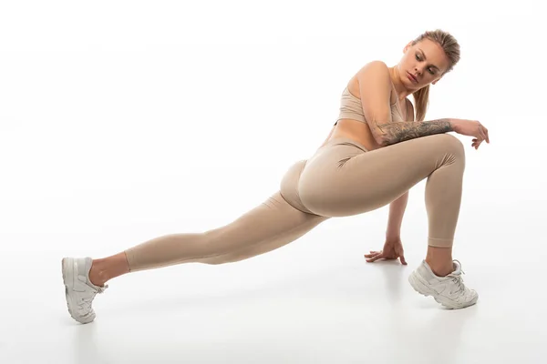 Sexy blondes Mädchen im beigen Outfit twerking isoliert auf weiß — Stockfoto