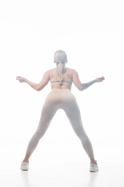 Visão traseira da menina loira em leggings bege twerking na fumaça isolada no branco — Fotografia de Stock