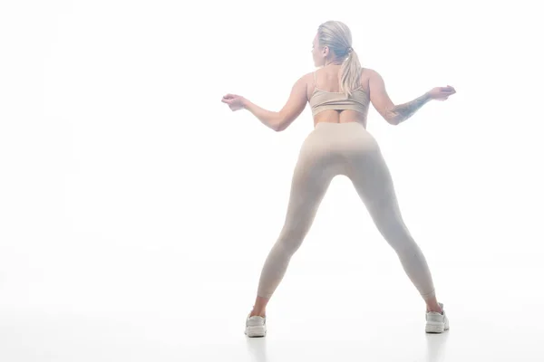 Vista posteriore della ragazza bionda in leggings beige twerking in fumo isolato su bianco — Foto stock