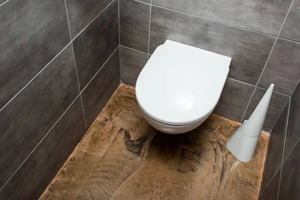 Ceramic clean toilet bowl in modern restroom with grey tile and toilet brush — Stock Photo