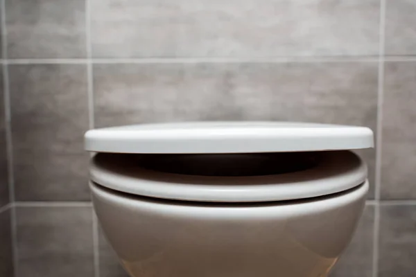 Close up view of ceramic clean toilet bowl with lid in modern restroom — Stock Photo