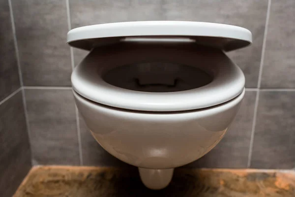 Close up view of ceramic clean toilet bowl with lid in modern restroom — Stock Photo