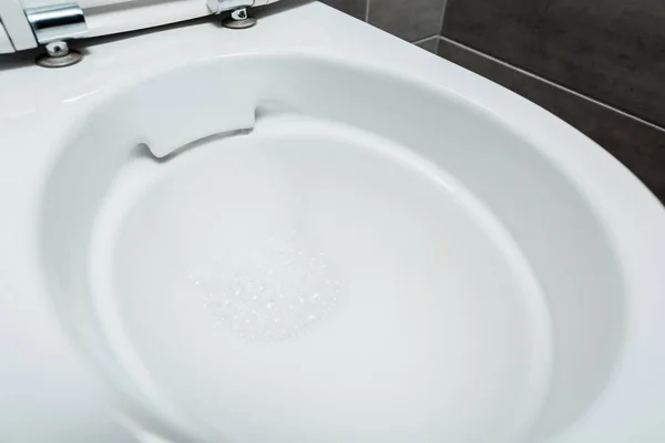 Vue rapprochée de la cuvette de toilette propre en céramique avec mousse dans les toilettes modernes — Photo de stock