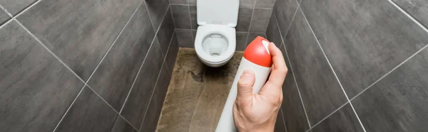 Vue recadrée de l'homme pulvérisation désodorisant dans les toilettes modernes avec tuile grise — Photo de stock