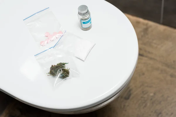 Lsd, bourgeons de marijuana, cocaïne et cannabis médical sur cuvette de toilette — Photo de stock