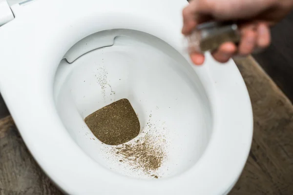 Vista cortada do homem jogando fora maconha em vaso sanitário — Fotografia de Stock