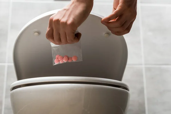 Ausgeschnittene Ansicht eines Mannes, der lsd in Toilettenschüssel wegwirft — Stockfoto