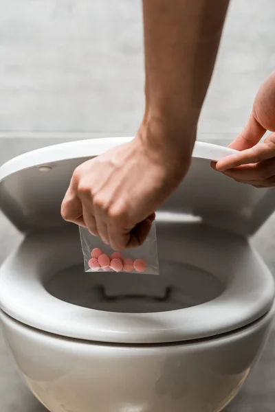 Ausgeschnittene Ansicht eines Mannes, der lsd in Toilettenschüssel wegwirft — Stockfoto
