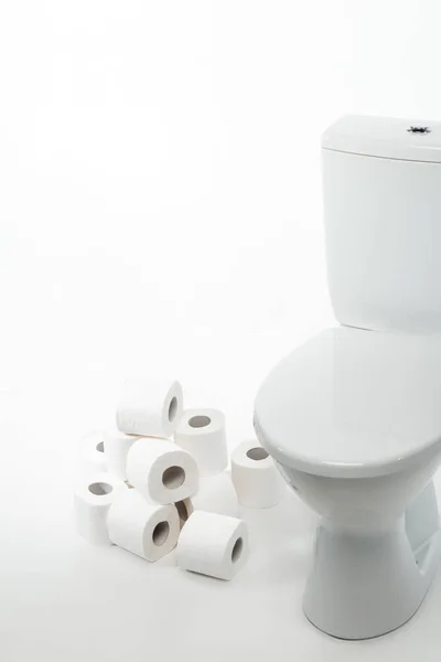 Bol de toilette en céramique propre avec rouleaux de papier toilette sur fond blanc — Photo de stock
