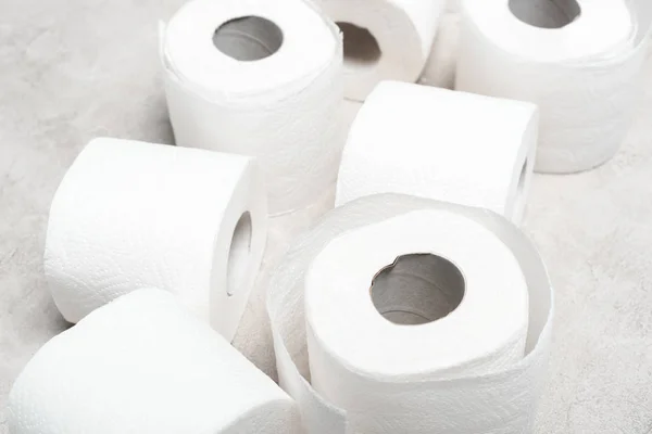 Close up view of rolls of toilet paper on grey textured surface — Stock Photo