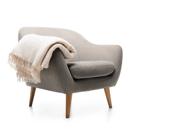Удобное серое современное кресло с одеялом, изолированным на белом — стоковое фото