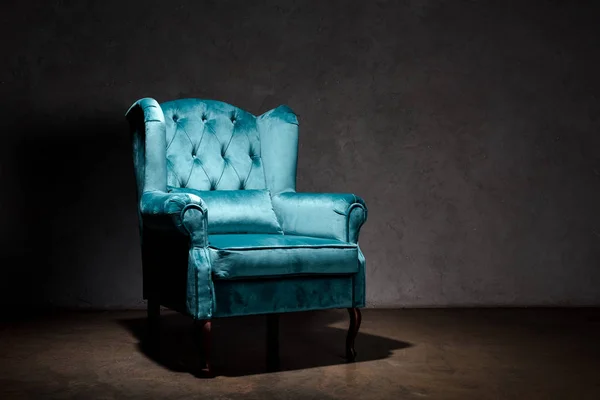 Elegant velour blue armchair near grey wall — Stock Photo