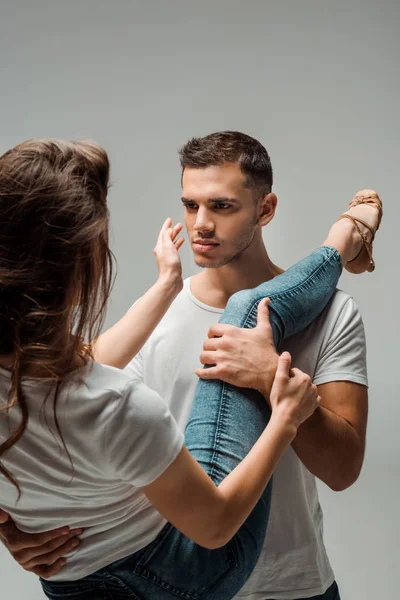 Bailarinas en camisetas y jeans bailando bachata aisladas en gris - foto de stock