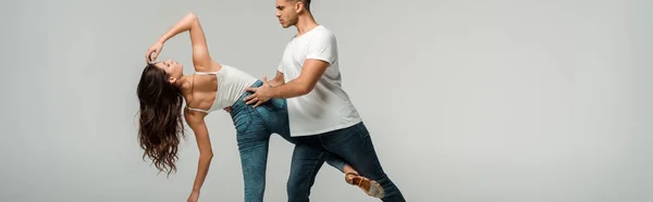 Panoramic shot of dancers dancing bachata isolated on grey — Stock Photo