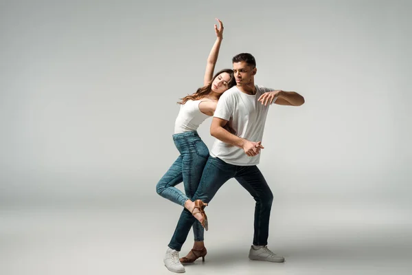 Bailarinos de olhos fechados dançando bachata em fundo cinza — Fotografia de Stock