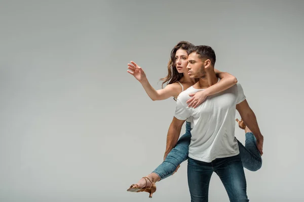 Tänzer in Jeans tanzen Bachata isoliert auf grau — Stockfoto