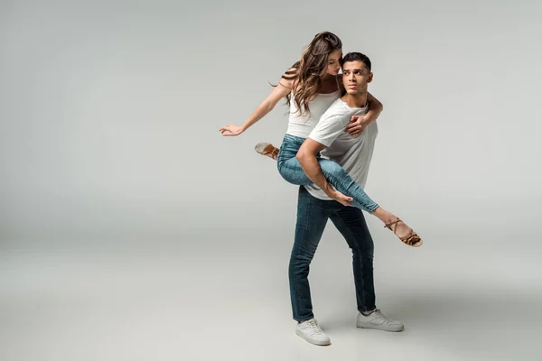 Dancers in denim jeans dancing bachata on grey background — Stock Photo