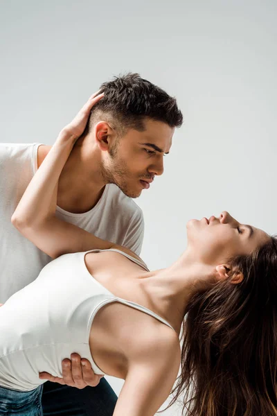 Bailarines con los ojos cerrados bailando bachata aislado en gris - foto de stock