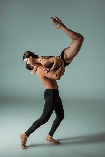 Sexy und attraktive Tänzerinnen tanzen zeitgenössisch auf grauem Hintergrund — Stockfoto