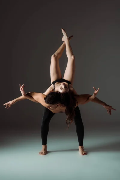 Сексуальные танцоры с закрытыми глазами танцуют современно на темном фоне — стоковое фото