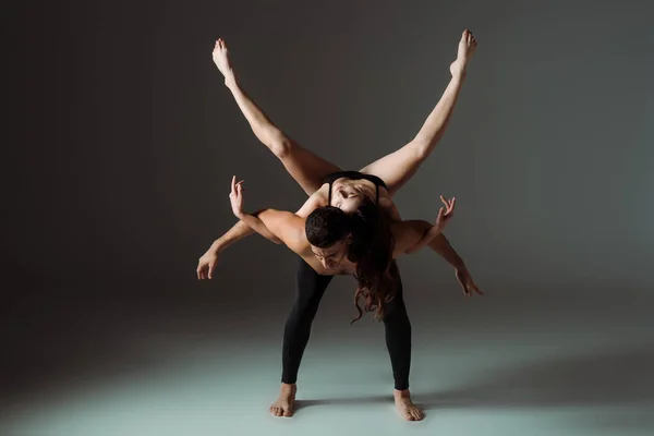 Sexy dancers dancing contemporary dance on dark background — Stock Photo