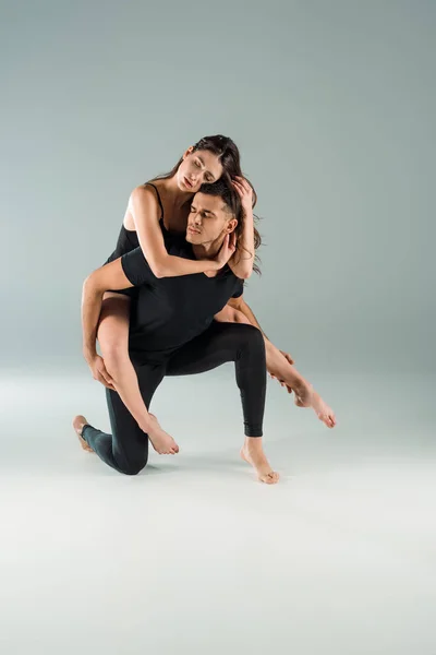 Tänzer mit geschlossenen Augen tanzen zeitgenössisch auf grauem Hintergrund — Stockfoto