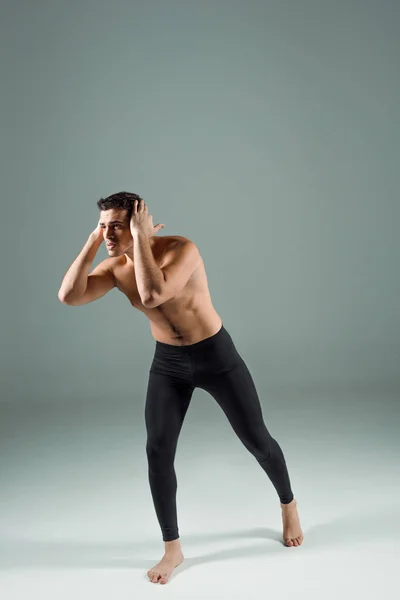 Handsome dancer in black leggings dancing contemporary on dark background — Stock Photo