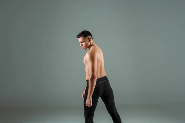 Handsome dancer in black leggings dancing contemporary on grey background — Stock Photo