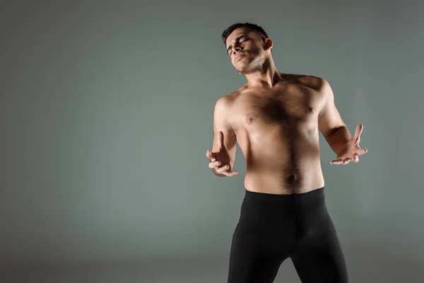 Guapo bailarín con los ojos cerrados en negro leggings bailando contemporáneo aislado en gris - foto de stock