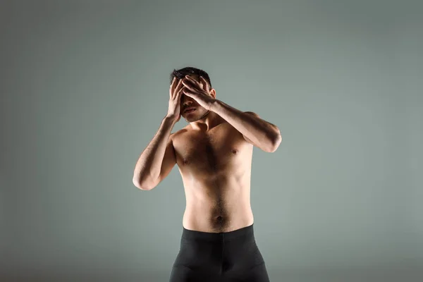 Dancer in black leggings dancing contemporary and obscuring face isolated on grey — Stock Photo