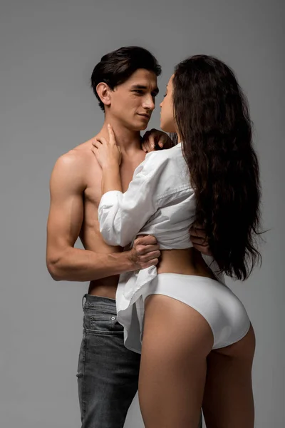 Jeune couple sensuel d'amoureux étreignant isolé sur gris — Photo de stock