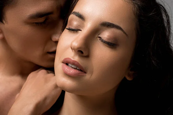 Beautiful sensual young couple hugging with closed eyes isolated on grey — Stock Photo