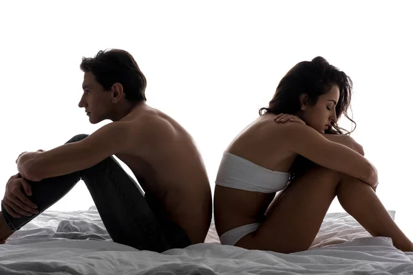Beau couple offensé assis dos à dos sur lit blanc — Photo de stock