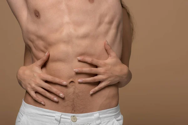 Cropped view of girl hugging torso of shirtless boyfriend isolated on beige — Stock Photo