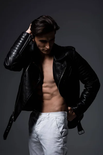 Сексуальный мужчина без рубашки в черной кожаной куртке, изолированный на сером — стоковое фото