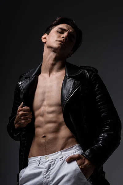 Hombre sexy sin camisa en chaqueta de cuero negro, aislado en gris - foto de stock