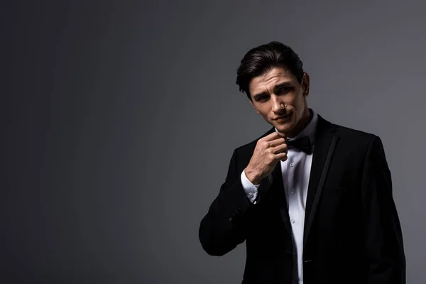 Hombre guapo en traje y lazo, aislado en gris - foto de stock