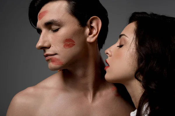 Mujer sensual y hombre con estampados de lápiz labial rojo, aislados en gris - foto de stock