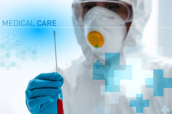 Selective focus of scientist doing dna test and standing near medical care illustration — Stock Photo