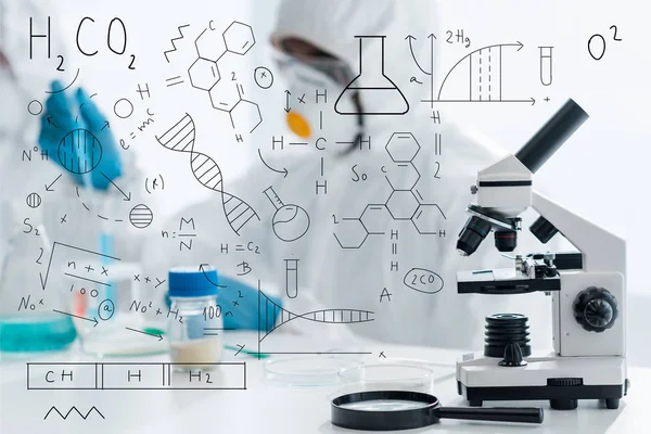 Selective focus of microscope and magnifying glass with formulas illustration — Stock Photo