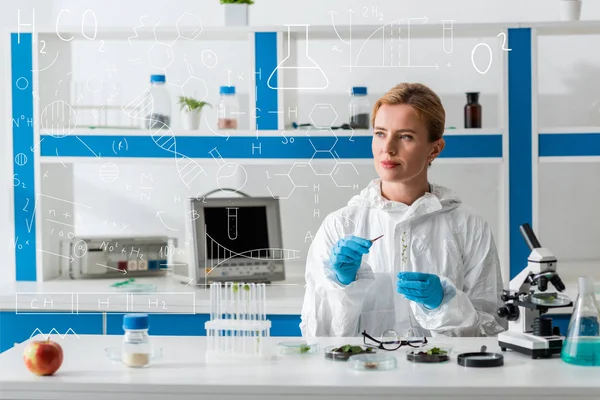 Attractive biologist holding test tube and sitting near illustration — Stock Photo